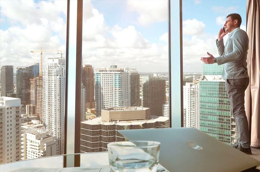 Man Standing in Office Building Window Man Standing in Office Building Window